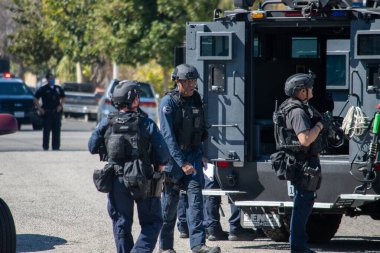 Reseda, California, ABD - 24 Şubat 2021: LAPD SWAT ekibi, polis memurları ve LAFD itfaiyecileri ve helikopterleri Reseda 'daki bir silahlı adam ihbarına yanıt verdiler. Şüphelilerden biri gözaltına alındı..
