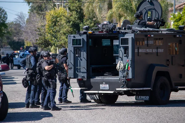 Reseda, California, ABD - 24 Şubat 2021: LAPD SWAT ekibi, polis memurları ve LAFD itfaiyecileri ve helikopterleri Reseda 'daki bir silahlı adam ihbarına yanıt verdiler. Şüphelilerden biri gözaltına alındı..