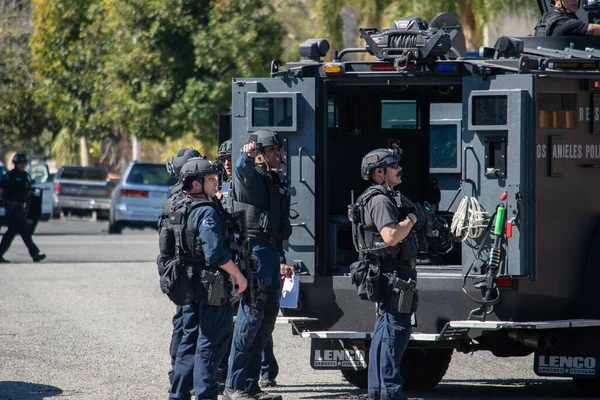 Reseda, California, ABD - 24 Şubat 2021: LAPD SWAT ekibi, polis memurları ve LAFD itfaiyecileri ve helikopterleri Reseda 'daki bir silahlı adam ihbarına yanıt verdiler. Şüphelilerden biri gözaltına alındı..