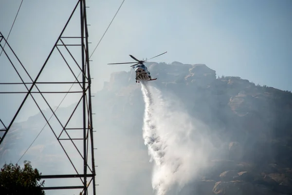 Chatsworth, California, ABD - 19 Ekim 2020: LAFD, LACFD ve VCFD 'den itfaiyeciler ve helikopterler Los Angeles ve Ventura' nın batısındaki Chatsworth tepelerinde bir çalı yangınıyla mücadele ediyor..
