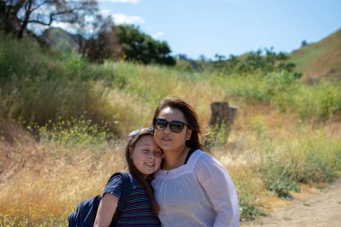 Bahar aylarında bir derede ya da nehirde oynarken birlikte gülüp duran kadın ve kız.