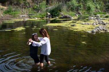 Doğayı keşfeden kadın ve kız baharda bir derede veya nehirde
