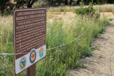 Malibu Creek Eyalet Parkı - 11 Mayıs 2019: Malibu ve Agoura 'daki 2018 yangınından sonra Malibu Creek Eyalet Parkı' nın iyileşmekte olan ağaç ve bitkilerini koruyan işaretler 2018 'deki Woolsey yangınları bölgede geniş çapta tahribata yol açtı ve yakıldı.