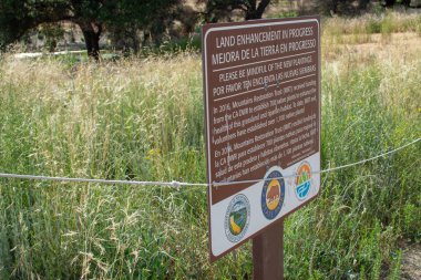 Malibu Creek Eyalet Parkı - 11 Mayıs 2019: Malibu ve Agoura 'daki 2018 yangınından sonra Malibu Creek Eyalet Parkı' nın iyileşmekte olan ağaç ve bitkilerini koruyan işaretler 2018 'deki Woolsey yangınları bölgede geniş çapta tahribata yol açtı ve yakıldı.