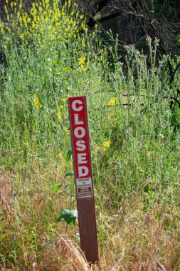 Malibu Creek Eyalet Parkı - 11 Mayıs 2019: Malibu ve Agoura 'daki 2018 yangınından sonra Malibu Creek Eyalet Parkı' nın iyileşmekte olan ağaç ve bitkilerini koruyan işaretler 2018 'deki Woolsey yangınları bölgede geniş çapta yıkıma yol açtı..