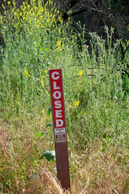 Malibu Creek Eyalet Parkı - 11 Mayıs 2019: Malibu ve Agoura 'daki 2018 yangınından sonra Malibu Creek Eyalet Parkı' nın iyileşmekte olan ağaç ve bitkilerini koruyan işaretler 2018 'deki Woolsey yangınları bölgede geniş çapta yıkıma yol açtı..