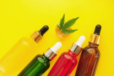 Esrar kozmetik ürünleri, cbd yağı. Marihuana özü kozmetolojide. Düz yatıyordu, sarı arka plan. Ev rahatlaması, spa eğlencesi, eğlence terapisi..