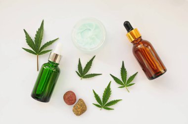 Marihuana yaprakları, cbd yağı, kozmetik krem. Taze kenevir yaprakları kapanıyor, beyaz arka planda izole edilmiş. Evde dinlenme, spa eğlencesi, eğlence terapisi. Modern kozmetoloji.