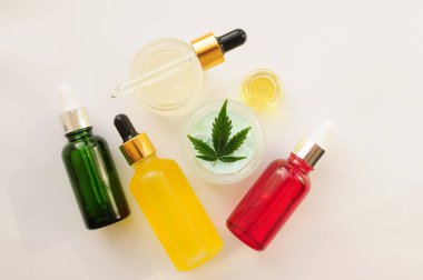 Marihuana yaprakları, cbd yağı, kozmetik krem. Kozmetolojide esrar özütü. Düz bir zemin, beyaz arka plan. Ev rahatlaması, spa eğlencesi, eğlence terapisi..