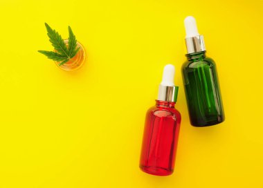 Esrar kozmetik ürünleri, cbd yağı. Marihuana özü kozmetolojide. Düz yatıyordu, sarı arka plan. Ev rahatlaması, spa eğlencesi, eğlence terapisi..