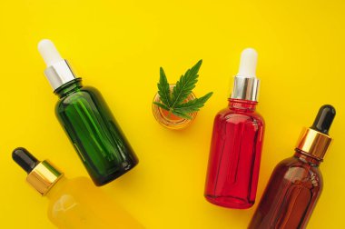 Esrar kozmetik ürünleri, cbd yağı. Marihuana özü kozmetolojide. Düz yatıyordu, sarı arka plan. Ev rahatlaması, spa eğlencesi, eğlence terapisi..