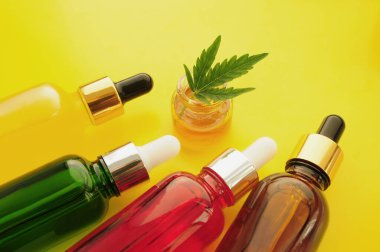 Esrar kozmetik ürünleri, cbd yağı. Marihuana özü kozmetolojide. Düz yatıyordu, sarı arka plan. Ev rahatlaması, spa eğlencesi, eğlence terapisi..