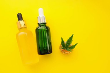 Esrar kozmetik ürünleri, cbd yağı. Marihuana özü kozmetolojide. Düz yatıyordu, sarı arka plan. Ev rahatlaması, spa eğlencesi, eğlence terapisi..