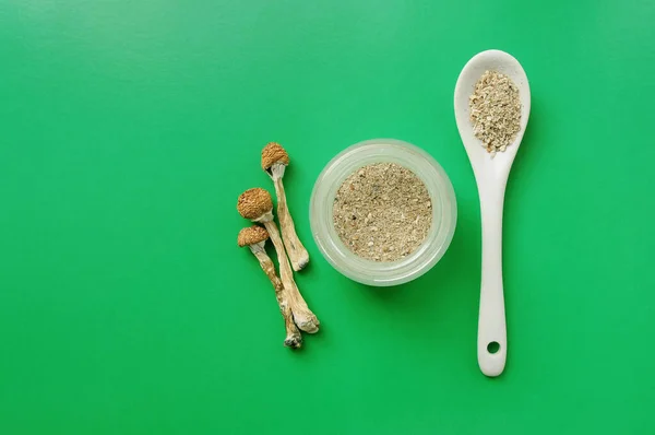 Mikrodoz konsepti. Yeşil arka planda kuru psilosibin mantarları. Doğal organik takviye. Tıbbi kullanım. Psikedelik sihir gezisi. 