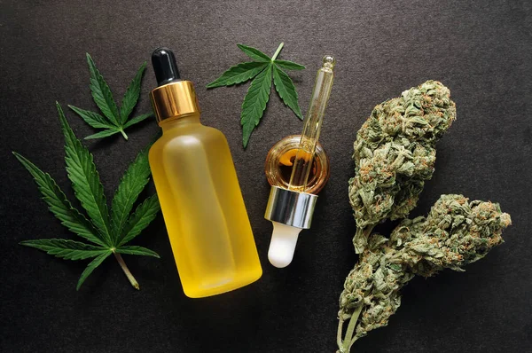 Marijuana extract in cosmetology. Cannabis blooms, cbd oil, organic cosmetics. Flat lay, black background. Home relaxation, spa recreation, pastime therapy.