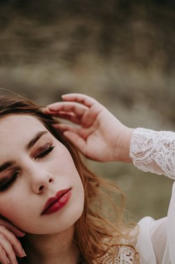 Gelinlik giymiş, kameraya poz vermiş güzel bir gelinin portresi. 