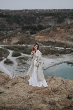 Nehirdeki kayalıklarda duran beyaz elbiseli güzel kız. 