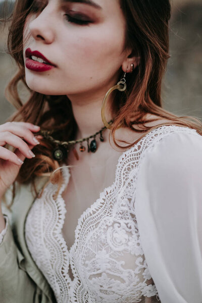 closeup of beautiful girl in a wedding dress holding  necklace