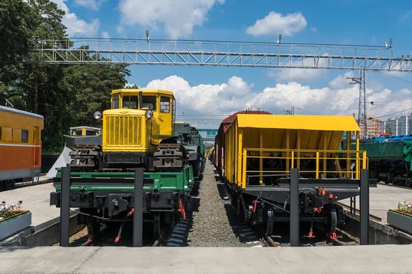 Vagão planform com trator na estação — Fotografia de Stock