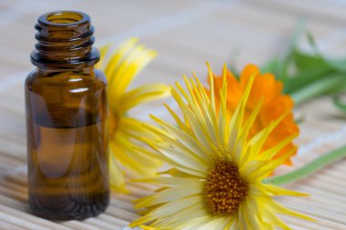 Bambu plaka üzerinde şişe ve calendula çiçek açmak