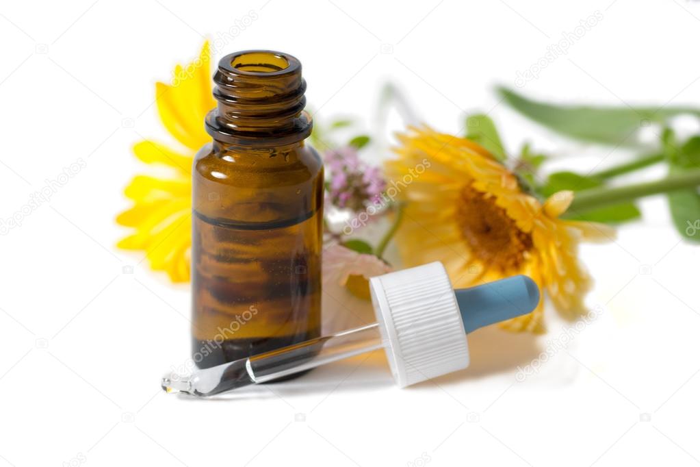 bottle and dropper with calendula and clower flowers