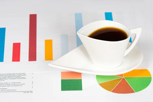 Xícara de café com barras coloridas e gráficos de torta — Fotografia de Stock