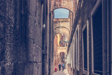 Dar sokakta yürürken iki erkekle ufuk arka plan