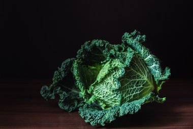 Savoy lahana karanlık bir arka plan karşı bir tahta masada