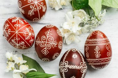 Kırmızı ve siyah el yapımı Paskalya Pysanka yumurtaları. Balmumuna dayanıklı boya tekniğiyle dekore edilmiş Ukrayna piranası. Beyaz tahta arkaplan