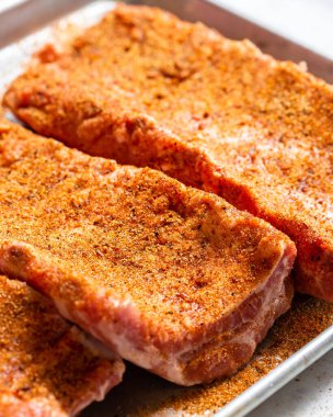 Erkek bir aşçının eli, çiğ et parçasına tuz ve baharat koyar. Çiğ St. Louis usulü barbekü kaburgaları Pişirmeye hazır