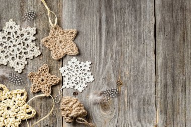 Winter or Christmas wooden background with crocheted stars and snowflakes. Handmade Christmas decorations made of natural materials. Top view, flat lay. clipart