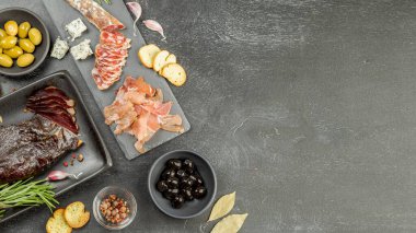 Türlü çeşit tütsülenmiş et. Ördek göğsü, kurutulmuş jambon ve siyah tahtada geleneksel kurutulmuş sosis. Metin için Boşluğu Kopyala