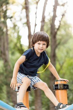 Oyun alanında spor malzemeleriyle oynayan küçük bir çocuk..