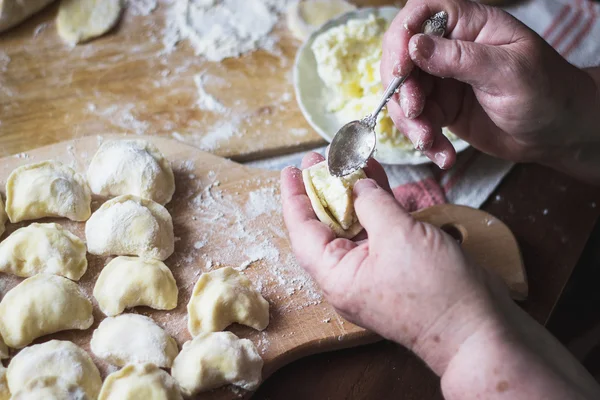 Büyükanne el vareniki süzme peynir ile yemek — Stok fotoğraf