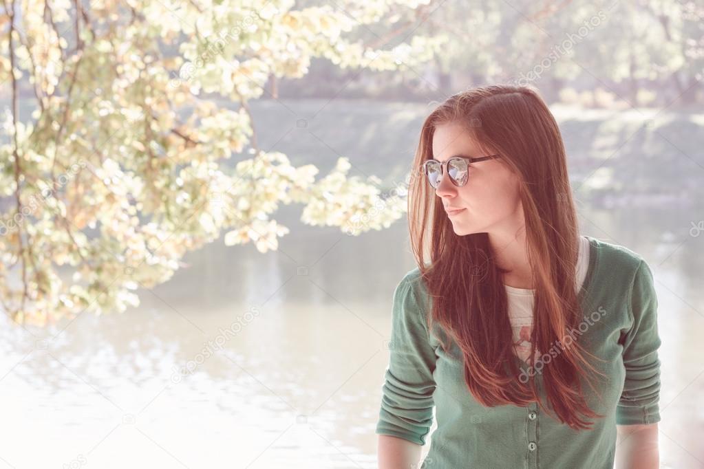 Beautiful young woman wearing green sweater and sun glasses