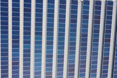 Ticari bir çatıdaki sıra sıra fotovoltaik güneş panellerinin hava görüntüsü, Sydney, Avustralya.