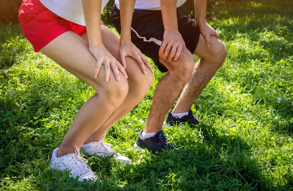 Pareja joven en cuclillas — Foto de Stock