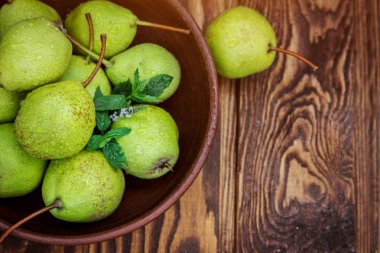 Nane ahşap masa üzerinde bir kase ile armut