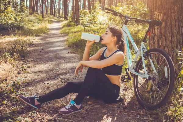 Bicyclist having a rest and drinking water — Stock Photo, Image