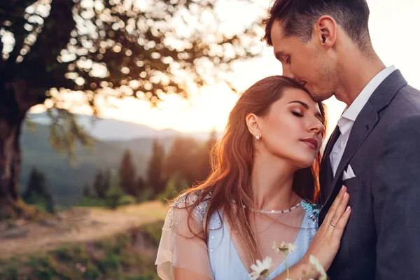 若い愛する結婚式のカップルは日没時に山に抱きつく 夏のカルパティアの花嫁と新郎の肖像画 バレンタインデーのロマンス — ストック写真