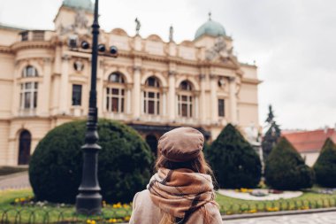 Polonya 'nın dışındaki Krakow Slowackiego tiyatrosuna hayran olan bir turist. Mimari, Krakow eski şehrinin simgeleri. Turist eğlencesi