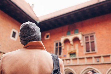 Ortaçağ Jagiellonian Üniversitesi, Collegium Maius, Krakow, Polonya 'da gezinin tadını çıkaran erkek turist. Avrupa 'yı dolaşmak