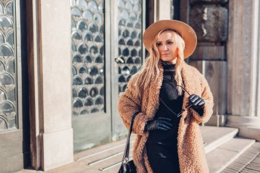 Bahar modasına uygun kadın aksesuarları. Şık bir kadın oyuncak ceketli ve elinde çantasıyla dışarıda dolaşıyor. Modern kıyafetler.