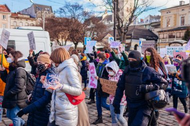 Lviv, Ukrayna - 8 Mart 2021: Uluslararası Kadınlar Günü için cinsiyetçiliğe karşı eşit haklar için feminist yürüyüş. Etrafı polislerle çevrili eylemciler