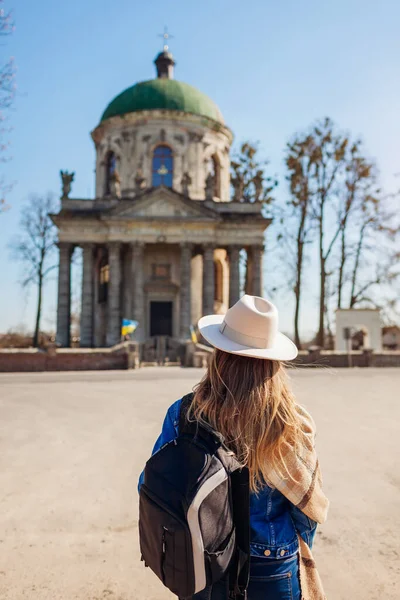 Tourist looking at ancient Roman Catholic church of saint Joseph in Pidhirtsi, Ukraine. Visiting ancient architecture landmarks and historic places