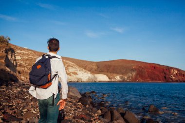 Akrotiri, Santorini, Yunanistan 'daki Kızıl Sahil manzarasına bakan bir gezgin. Seyahat ediyorum. Yaz tatili