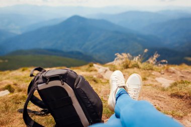 Karpat dağlarında yürüyüş. Yürüyüş yapan kadın sırt çantasıyla rahatlıyor ve manzaranın tadını çıkarıyor. Yazın Ukrayna 'da seyahat. Ayakkabılarınızı kapatın.