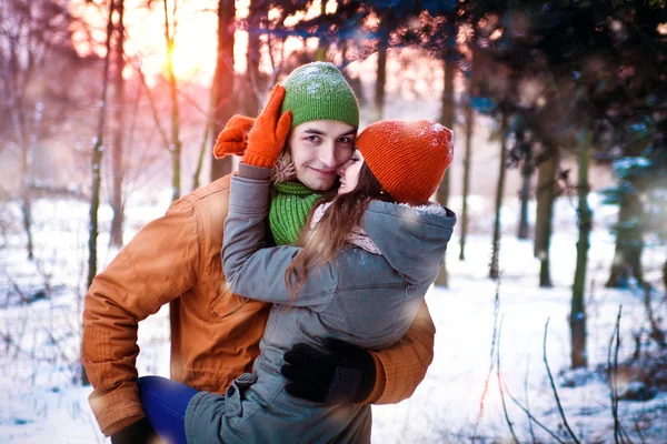 Jovem casal apaixonado abraçando na floresta de inverno — Fotografia de Stock