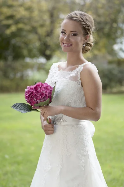 Brud med blommor i trädgården — Stockfoto