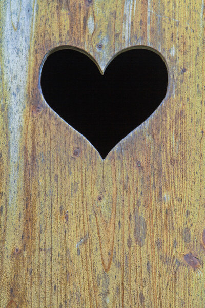 Маленькое сердце в деревянной двери
